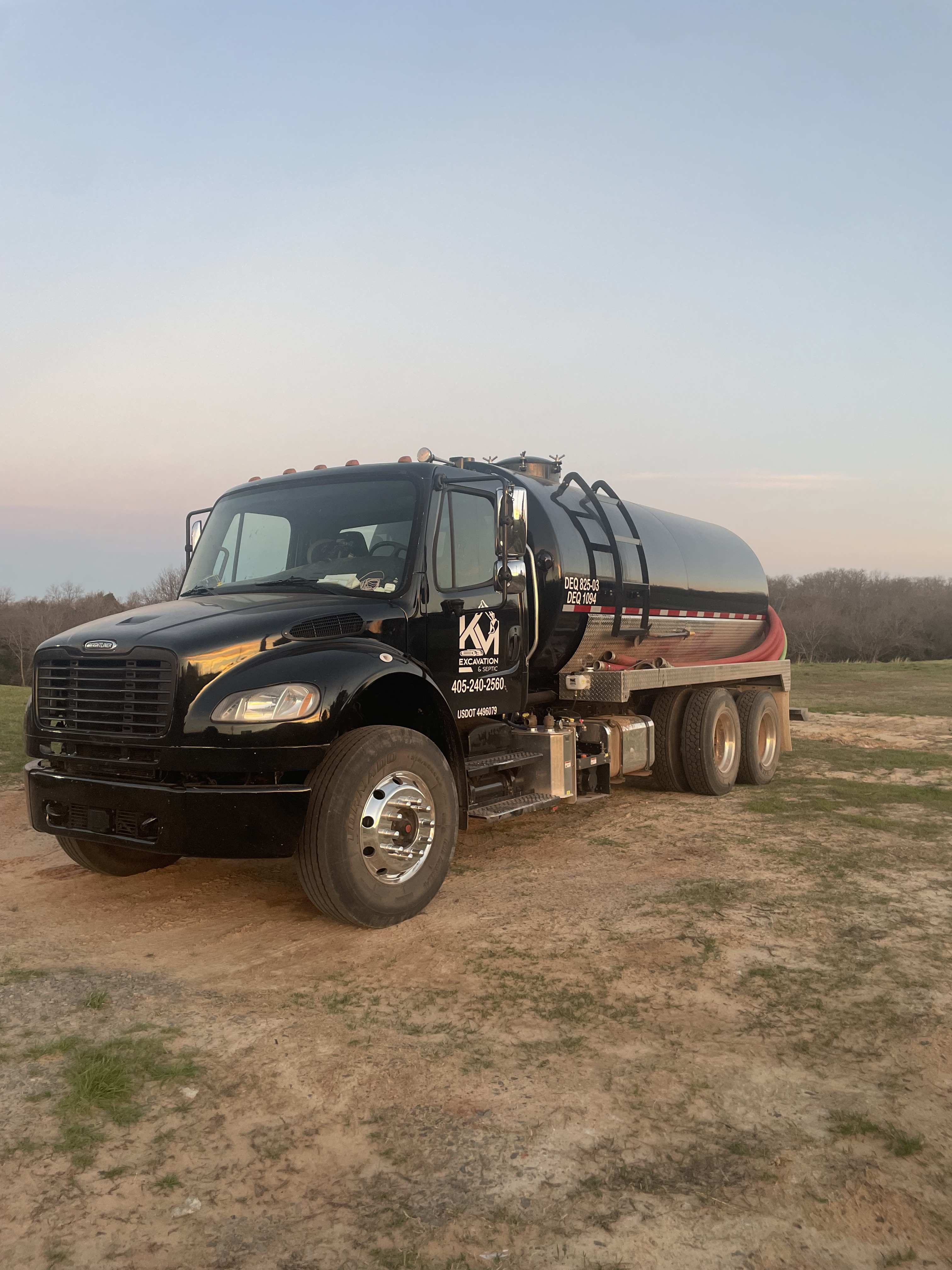 K&M Excavation and Septic pump truck parked on a job site at dusk